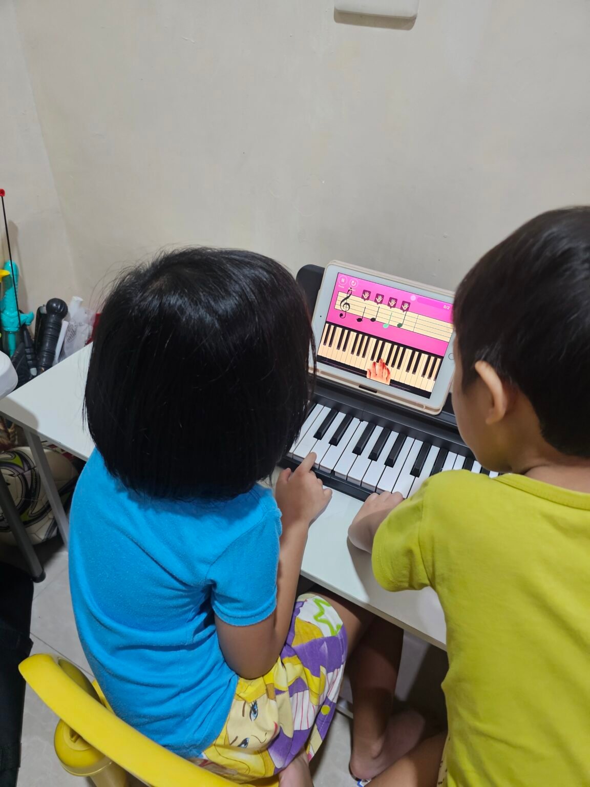 T watching K do her piano lesson